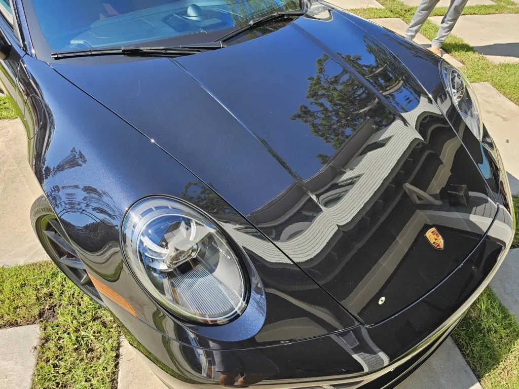 Black Porsche 911 hood with mirror reflections