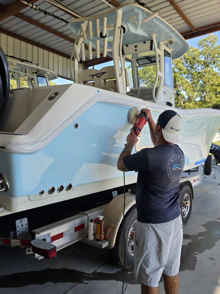 Polishing the hull side of a center console on its trailer in the Elite shop