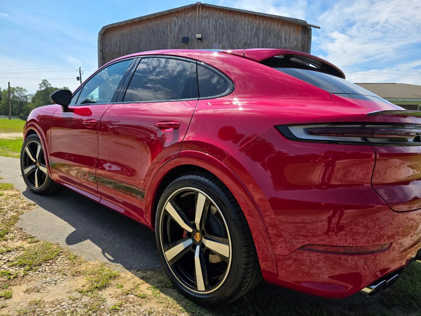 Red Porsche Cayenne Coupe in the sun, rear three-quarter view