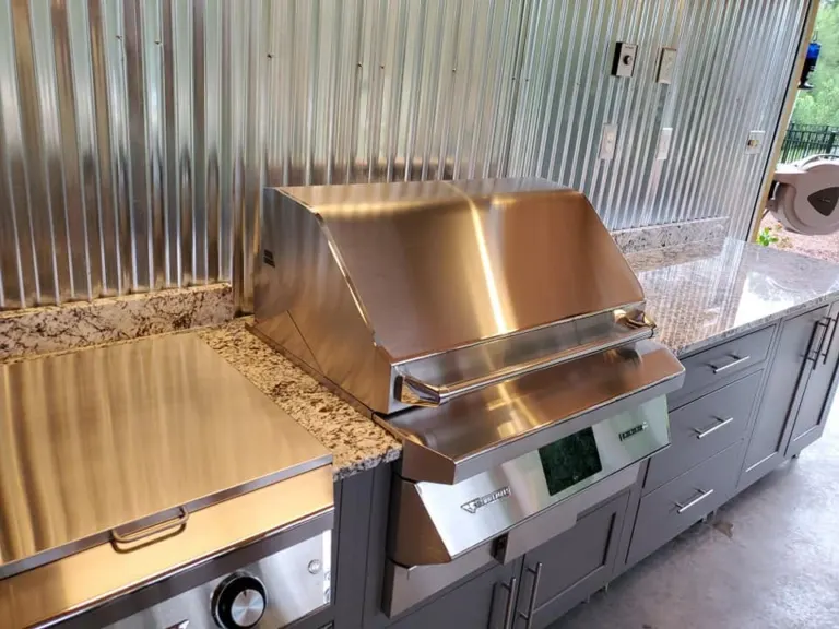 Stainless grill and stone counter in an outdoor kitchen, close view