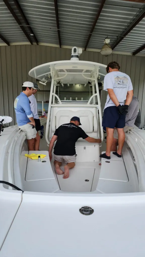 Trainees working in a center console cockpit during a System X boat coating class
