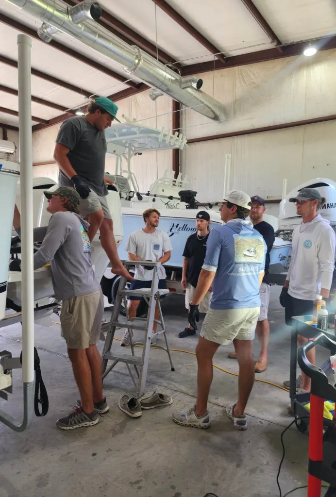 A System X boat coating training group watching a hands-on demo