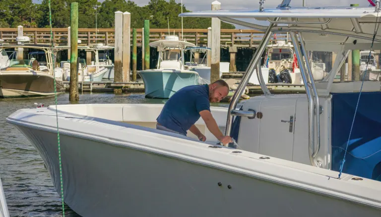 Working on a white center console at the marina